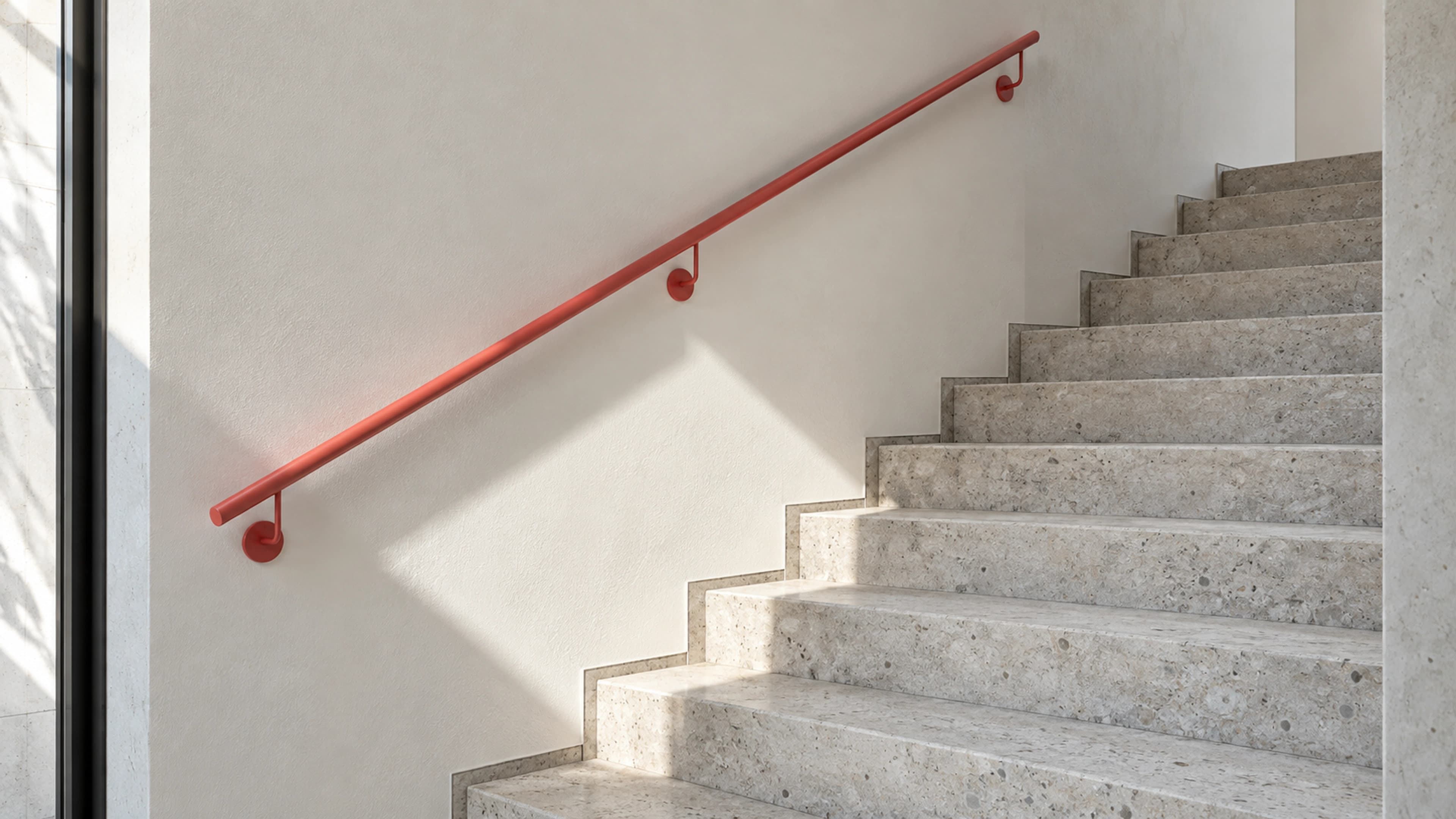 Treppe mit korallfarbenem Handlauf